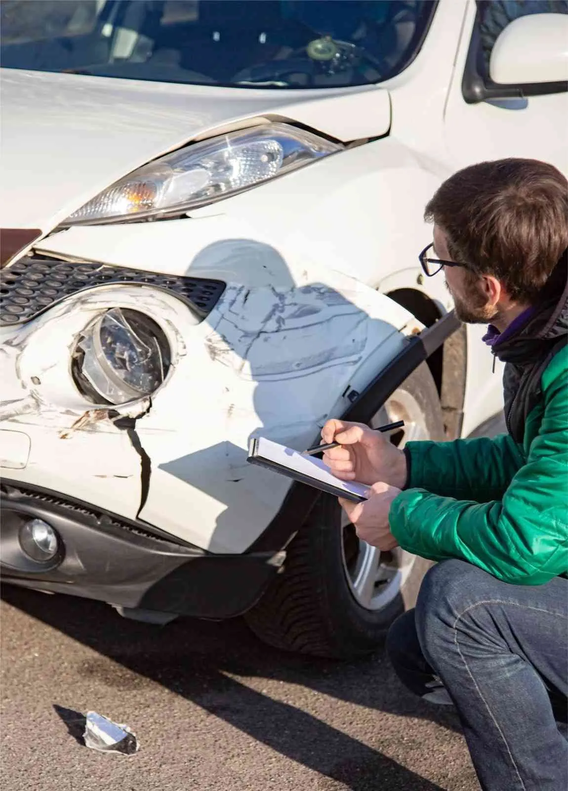 Inspecting bumper damage on a car after a collision